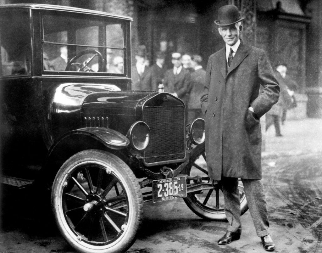 Der Unternehmer Henry Ford vor einem seiner Fahrzeuge.