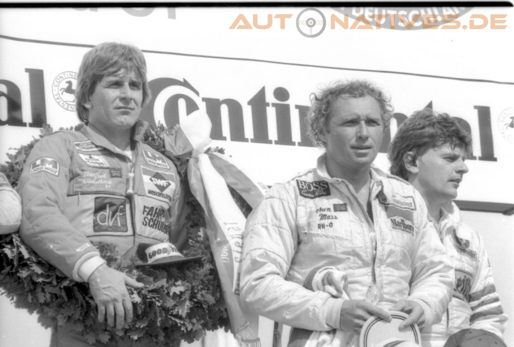 Manfred Winkelhock (Links) und Jochen Mass (rechts) auf dem Podium nach dem DRM-Lauf im Rahmenprogramm des Großen Preis von Deutschland 1981. Winkelhock gewann den Lauf der Division I im Ford Capri III Turbo 1.7. – Ein Jahr später, im Juni 1982, war Winkelhock selbst in der Formel 1 aktiv. Foto: Archiv AutoNatives.de